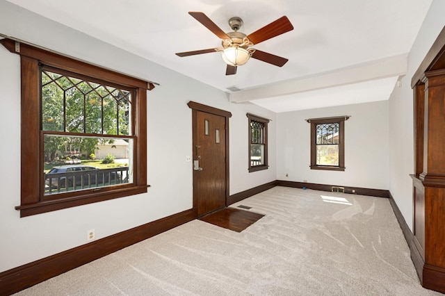 interior space with beamed ceiling, carpet, and ceiling fan