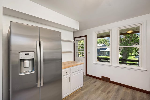 kitchen with white cabinetry, light hardwood / wood-style flooring, wooden counters, and stainless steel fridge with ice dispenser