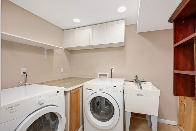 laundry area with cabinets, sink, independent washer and dryer, and light tile patterned flooring