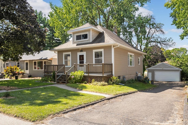 bungalow-style home featuring a deck, central AC, a front yard, a garage, and an outbuilding