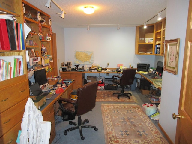 office space with track lighting, a textured ceiling, and concrete floors