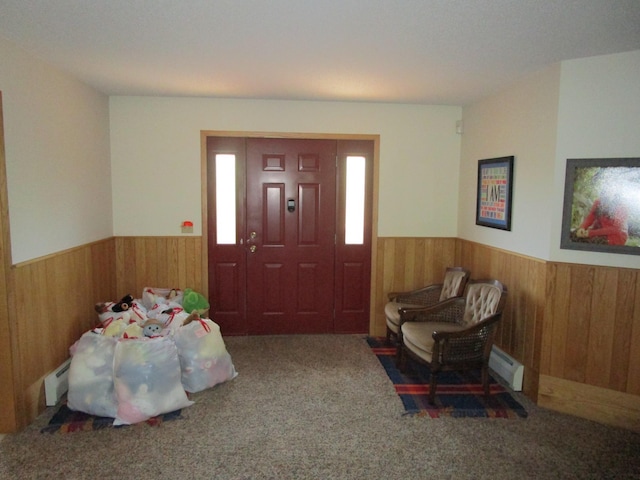 carpeted foyer featuring wooden walls and baseboard heating