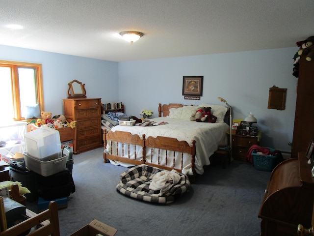 bedroom with a textured ceiling and dark carpet