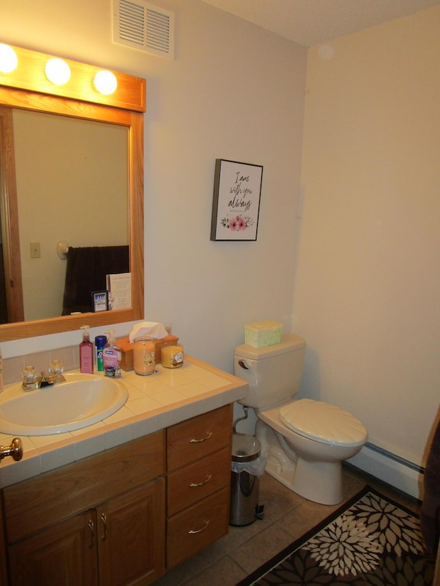 bathroom with a baseboard radiator, vanity, toilet, and tile patterned floors