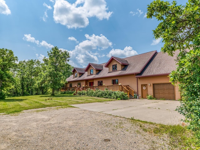 view of front of property featuring a garage, a deck, and a front lawn