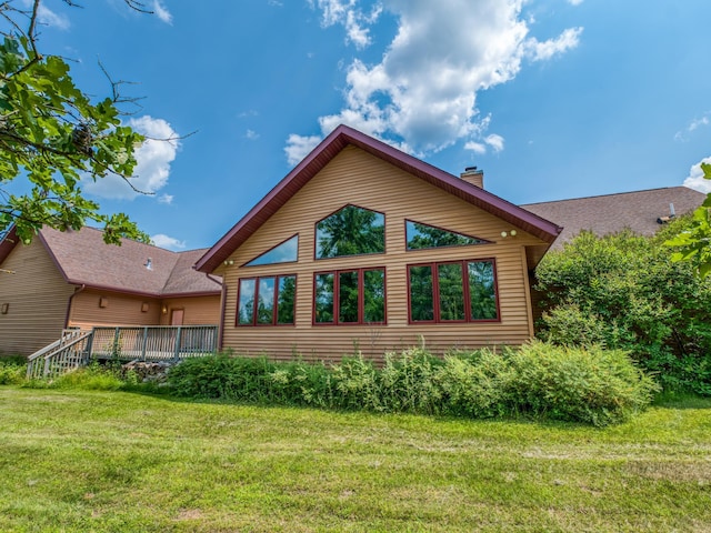 back of property featuring a yard and a deck