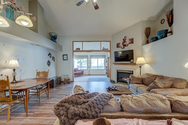 living room featuring wood-type flooring, high vaulted ceiling, and ceiling fan