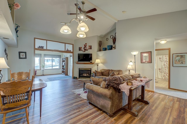 living room featuring hardwood / wood-style flooring, vaulted ceiling with beams, and ceiling fan