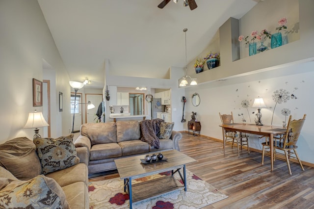 living room featuring hardwood / wood-style floors, high vaulted ceiling, and ceiling fan