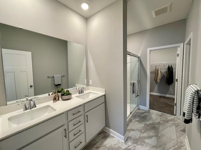 bathroom with vanity and a shower with door