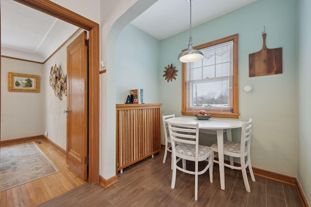 dining area with wood-type flooring and radiator heating unit