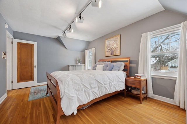 bedroom with vaulted ceiling and hardwood / wood-style floors