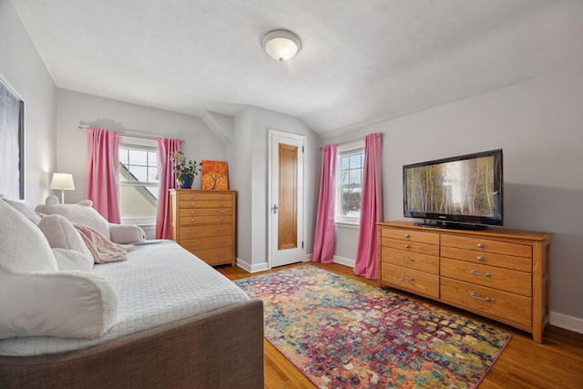 bedroom featuring wood-type flooring and vaulted ceiling