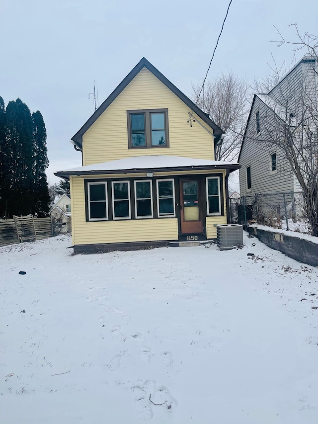 snow covered rear of property featuring central air condition unit