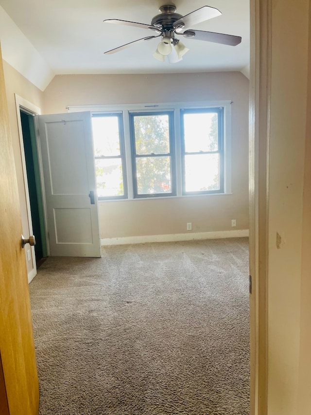 spare room with ceiling fan, lofted ceiling, and carpet