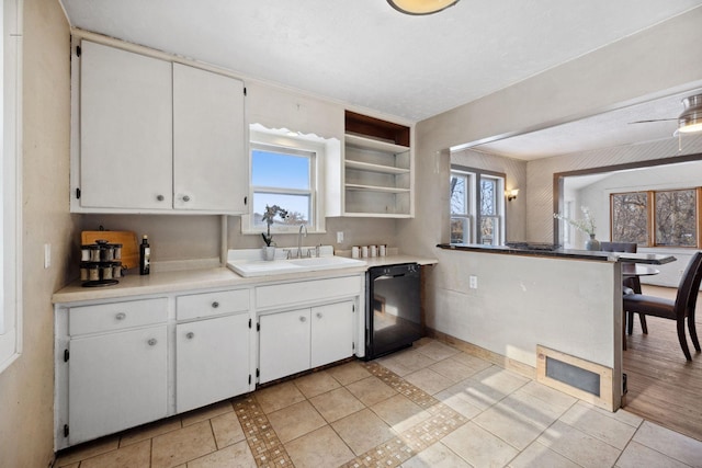 kitchen with open shelves, white cabinetry, light countertops, and dishwasher