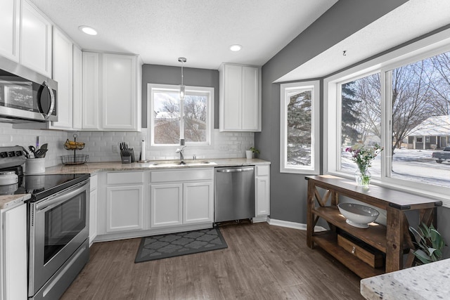 kitchen with white cabinetry, sink, pendant lighting, and appliances with stainless steel finishes