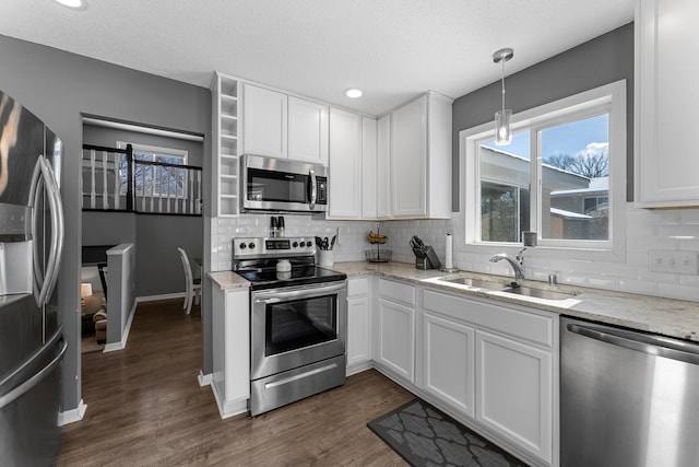 kitchen with stainless steel appliances, white cabinetry, and sink