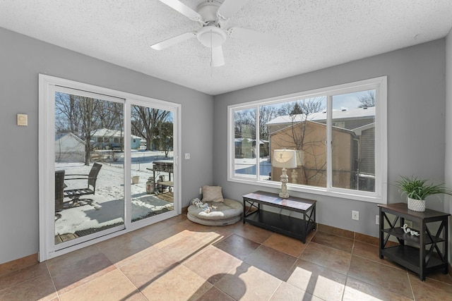 living area featuring ceiling fan and a textured ceiling