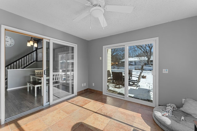 interior space with ceiling fan and a textured ceiling