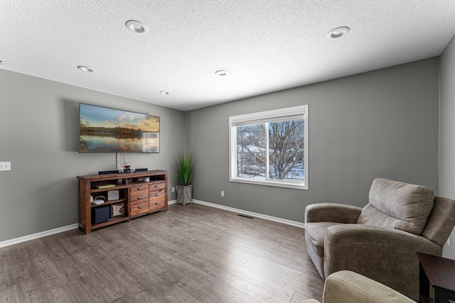 sitting room with hardwood / wood-style flooring and a textured ceiling