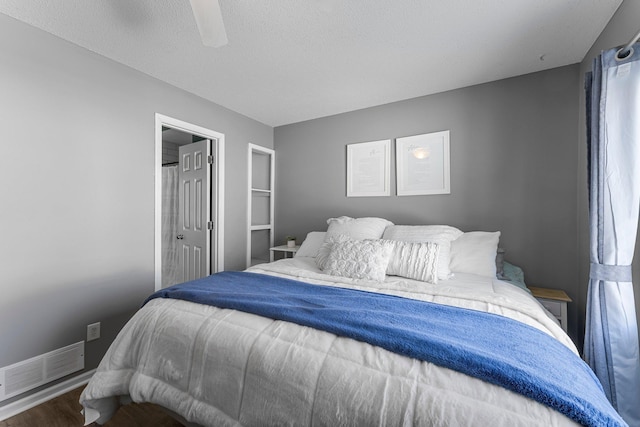 bedroom featuring a textured ceiling, dark hardwood / wood-style floors, and ceiling fan