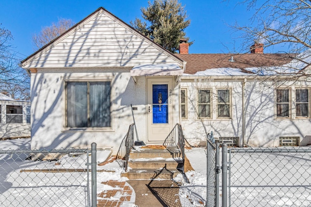 bungalow featuring a chimney, roof with shingles, a gate, fence, and stucco siding