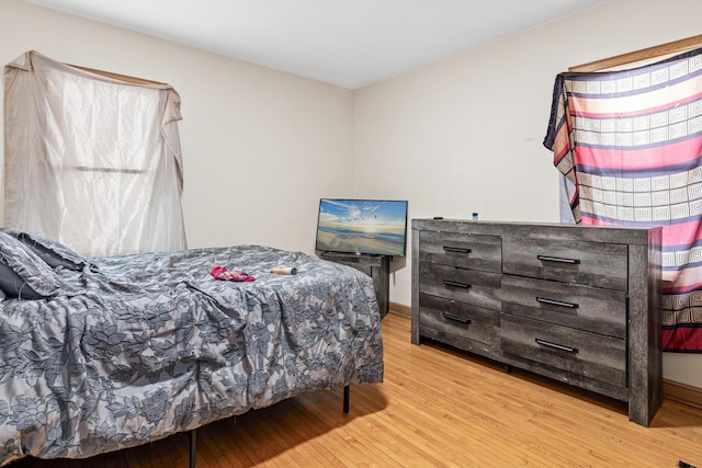 bedroom featuring baseboards and wood finished floors