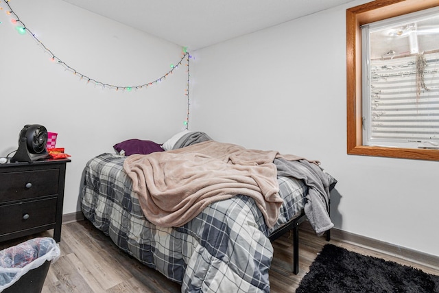 bedroom featuring baseboards and wood finished floors