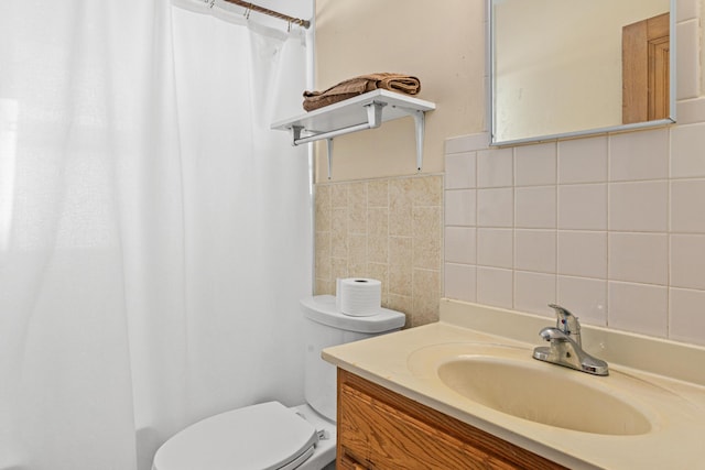 full bath featuring a shower with shower curtain, tile walls, toilet, and vanity