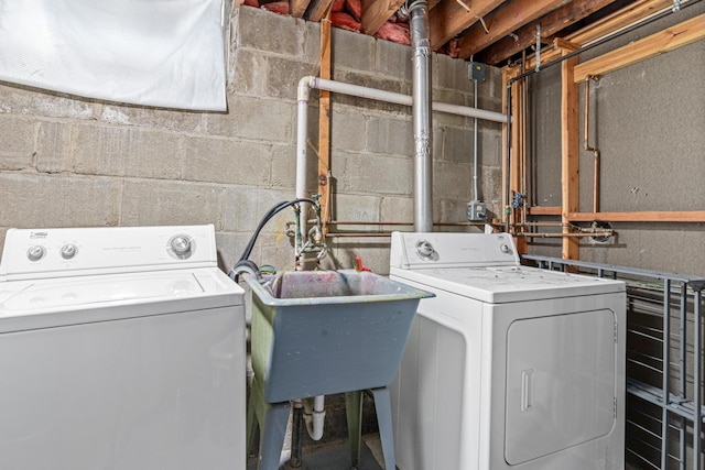 laundry area with laundry area, a sink, and washing machine and clothes dryer