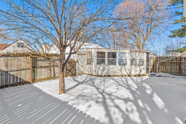 snow covered deck featuring a fenced backyard