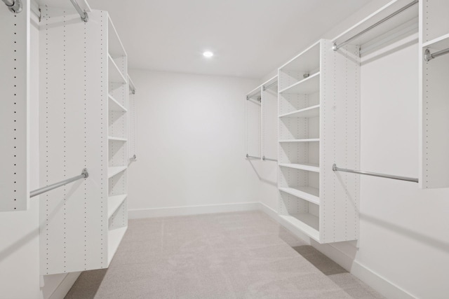 walk in closet featuring light carpet