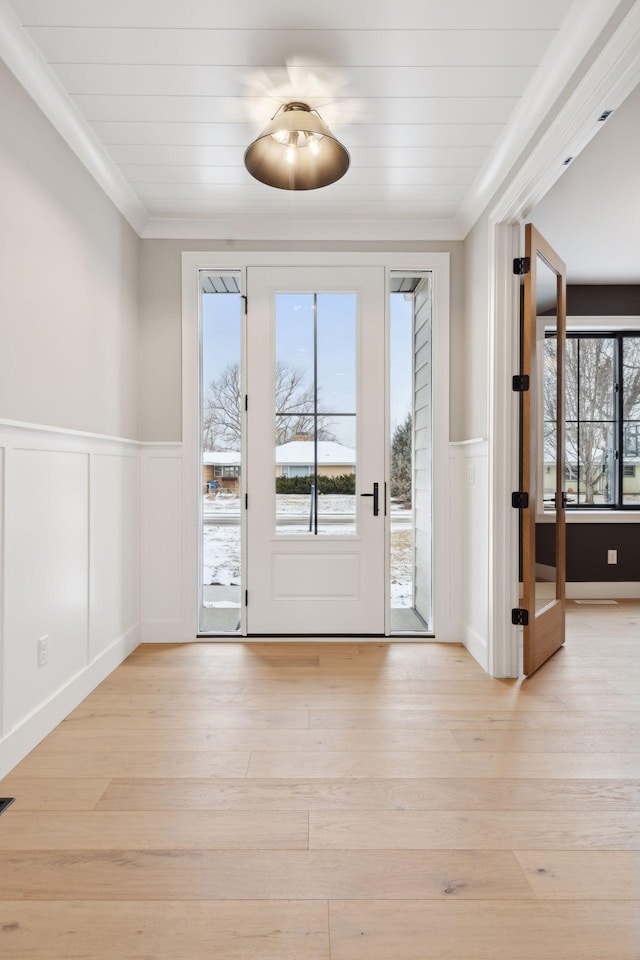 doorway featuring ornamental molding and light hardwood / wood-style flooring