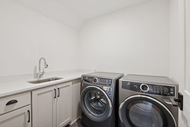 laundry area with cabinets, washer and clothes dryer, and sink