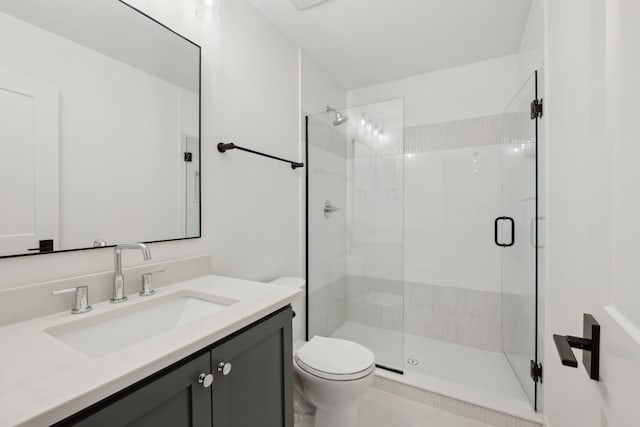 bathroom with vanity, a shower with shower door, and toilet