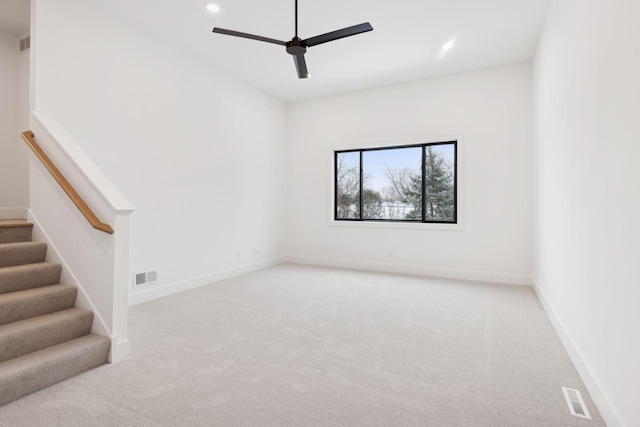 carpeted spare room featuring ceiling fan