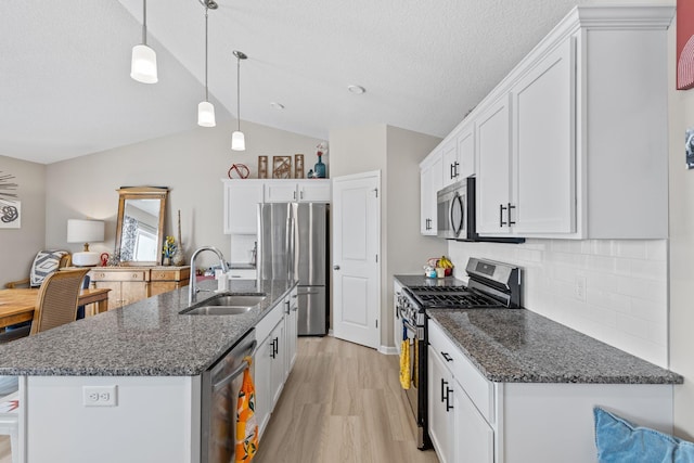 kitchen featuring sink, a kitchen island with sink, hanging light fixtures, stainless steel appliances, and white cabinets