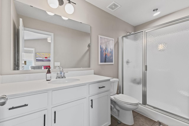 bathroom with vanity, toilet, tile patterned floors, and walk in shower