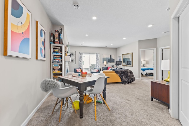 dining area with light carpet and a textured ceiling