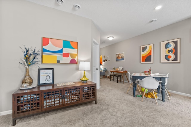 interior space featuring light colored carpet and a textured ceiling