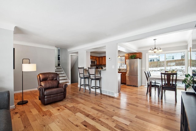 living area with a notable chandelier and light hardwood / wood-style flooring