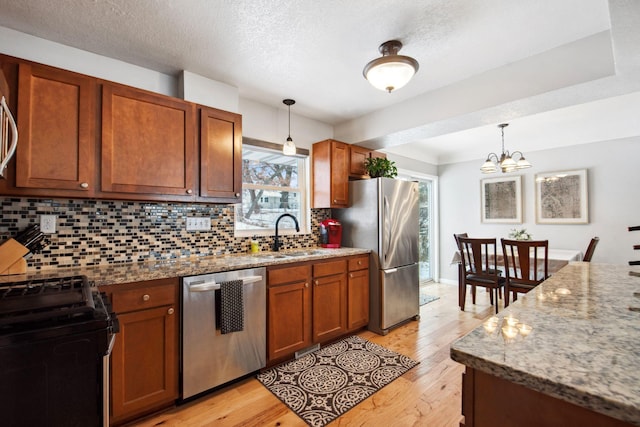 kitchen with tasteful backsplash, sink, stainless steel appliances, and light stone countertops