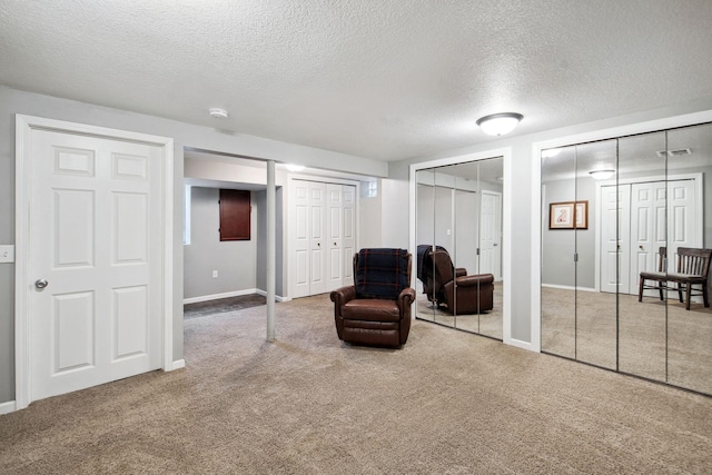 sitting room featuring carpet floors and a textured ceiling