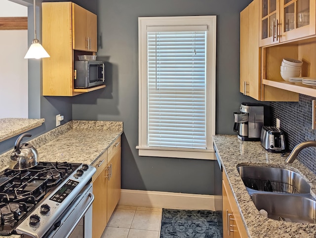 kitchen with sink, decorative backsplash, hanging light fixtures, stainless steel appliances, and light stone countertops