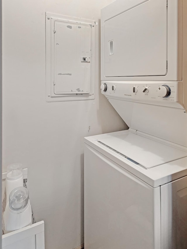 laundry room featuring stacked washer and clothes dryer and electric panel