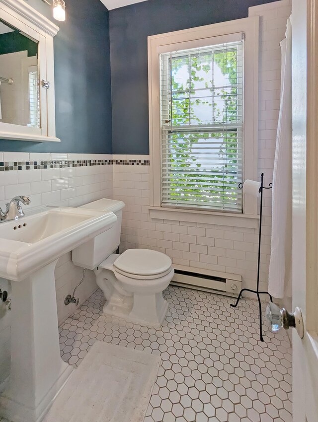 bathroom with tile patterned flooring, a baseboard radiator, tile walls, and toilet