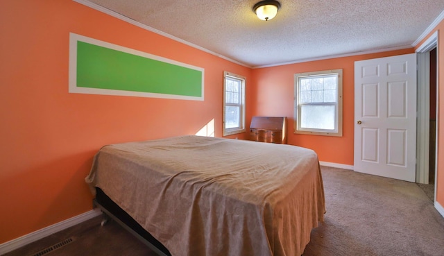 bedroom featuring ornamental molding, carpet flooring, baseboards, visible vents, and a textured ceiling