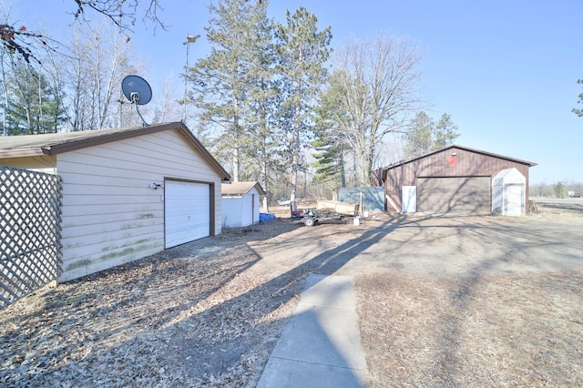 exterior space with a garage, an outbuilding, and driveway