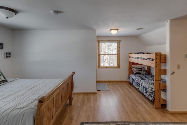 bedroom with lofted ceiling and light wood-type flooring